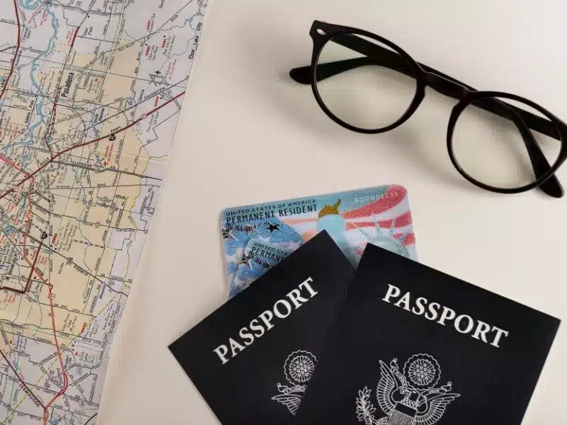  Travel essentials, including passports and map highlighting need for Driving Licence Translation for Expats.
