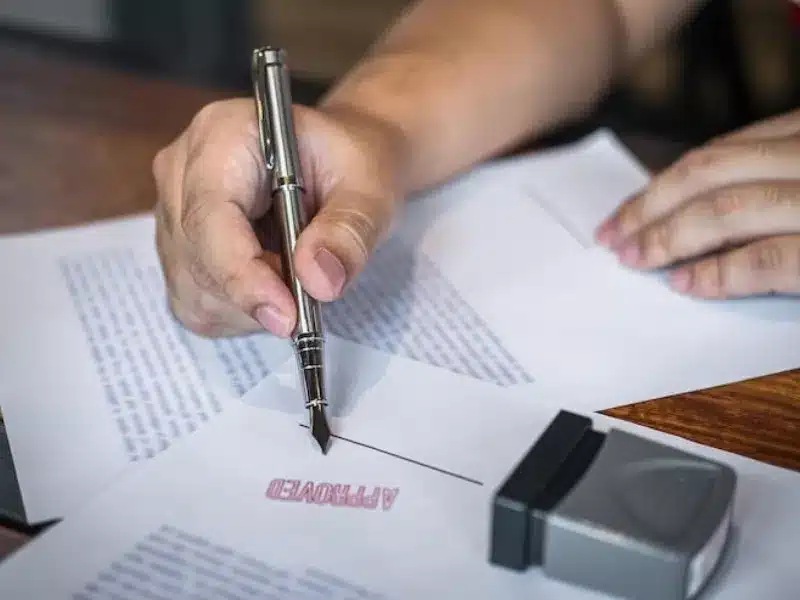 Official signing a document for a Sworn vs Notarised Translation UK verification<br />
